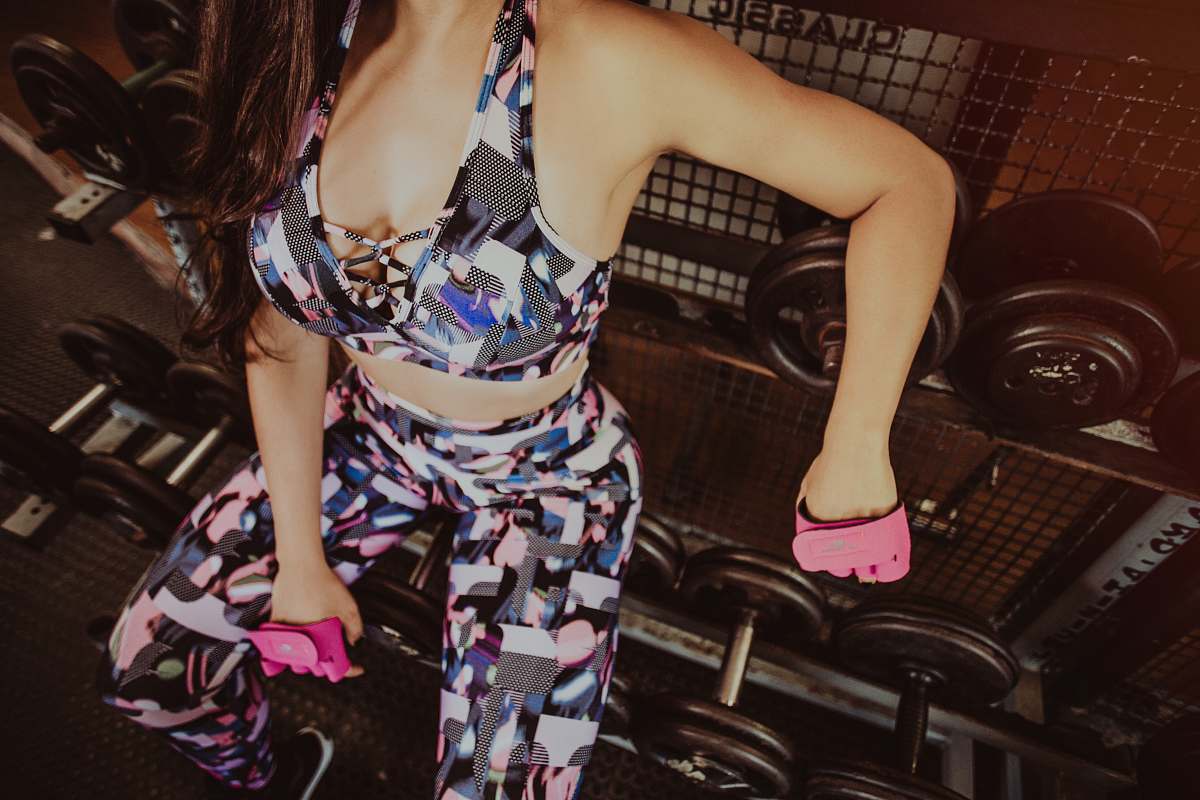 apparel woman sitting on dumbbells on rack evening dress