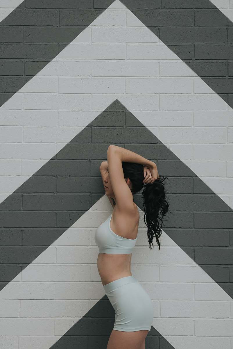 human woman standing beside brick wall person
