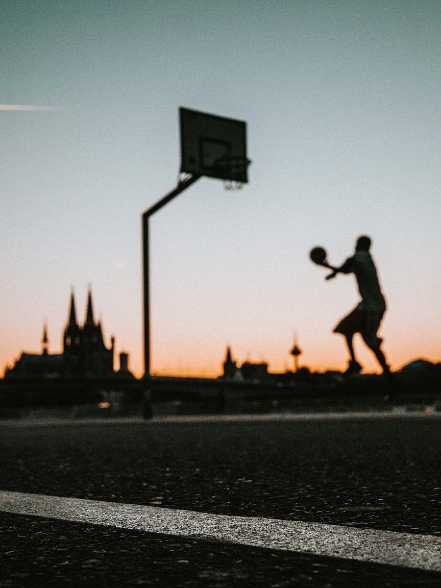 germany man holding ball jumping near portable basketball hoop silhouette
