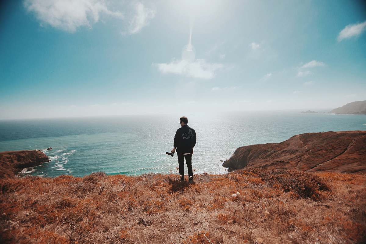 jogging man in black jacket standing on brown grass fitness
