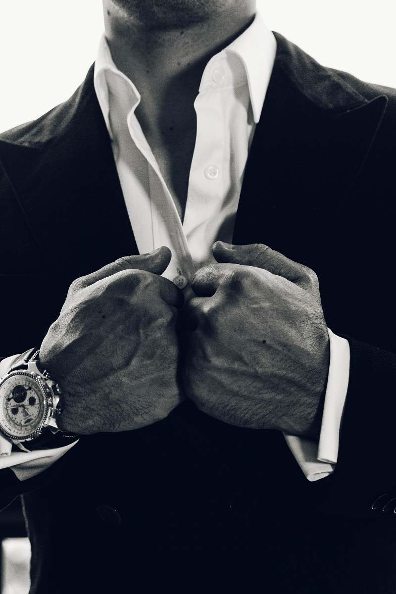 suit grayscale photography of man's suit wristwatch