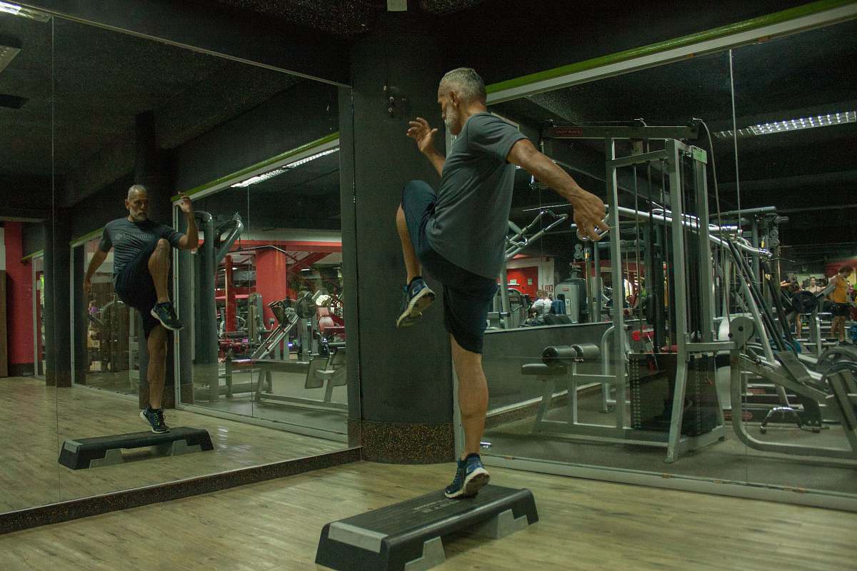human man wearing grey shirt and black shorts doing exercise person