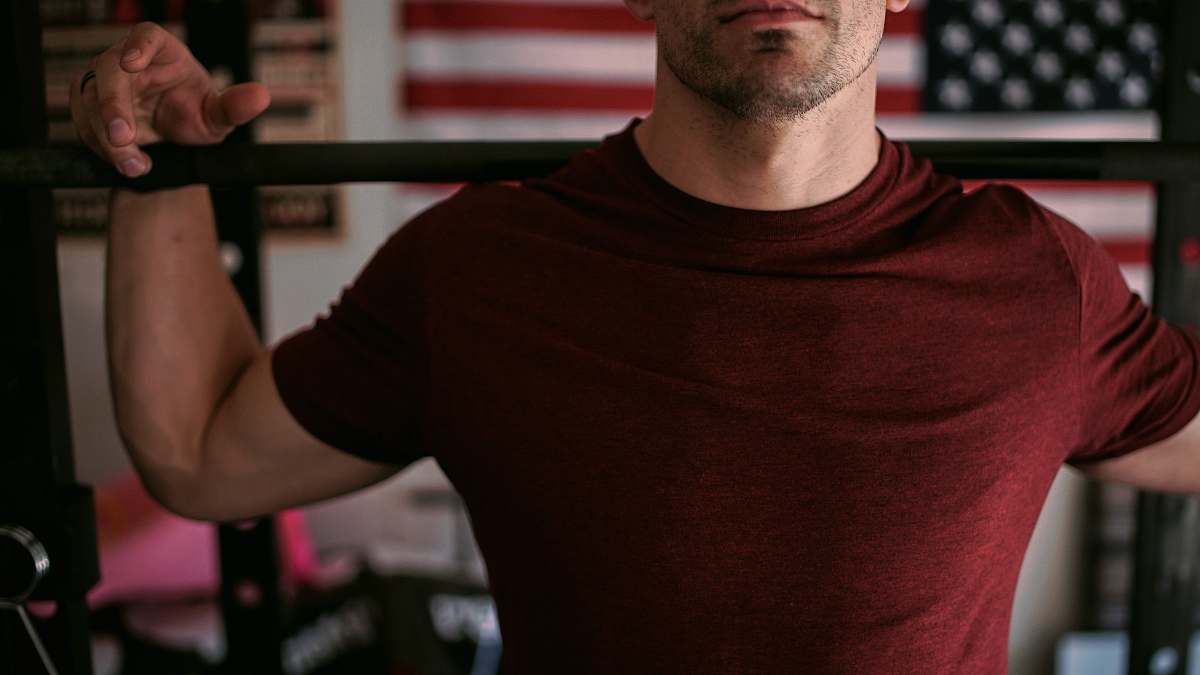 people man wearing red crew-neck shirt carrying barbell human