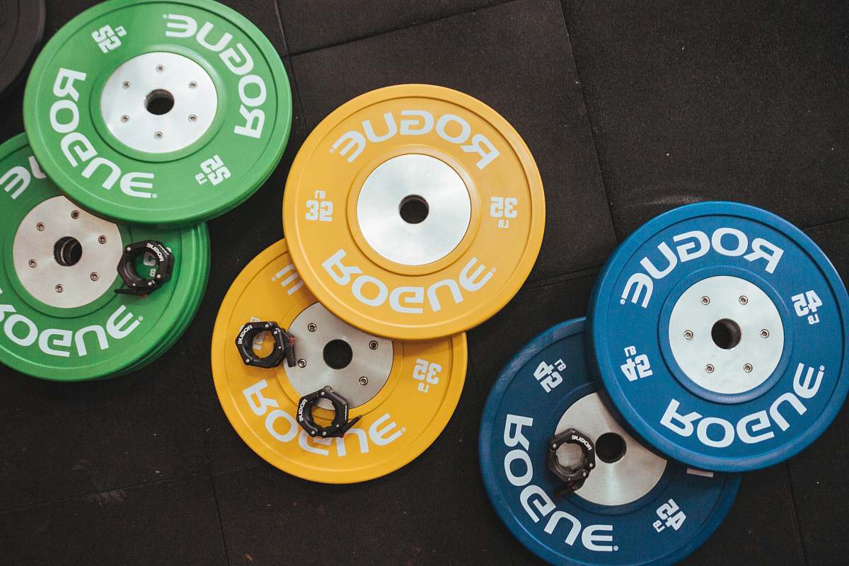 muscle three pairs of assorted-color Rogue bumper plates muscles