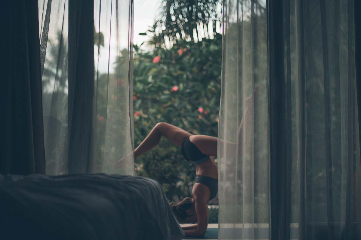 yoga woman in black bikini doing yoga grey
