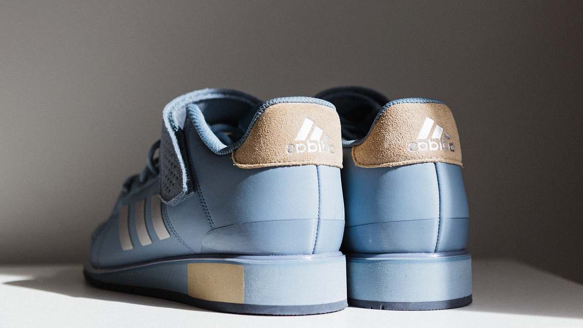 clothing pair of blue-and-brown adidas low-top sneakers on white board shoe