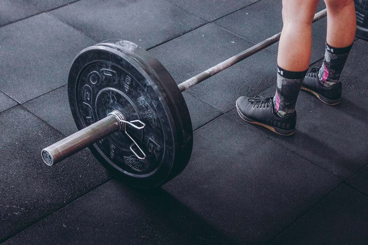 shoe person standing in front of gray and black barbell clothing