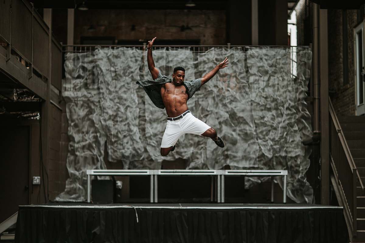 austin man raising his both hands while on air in front of stage united states