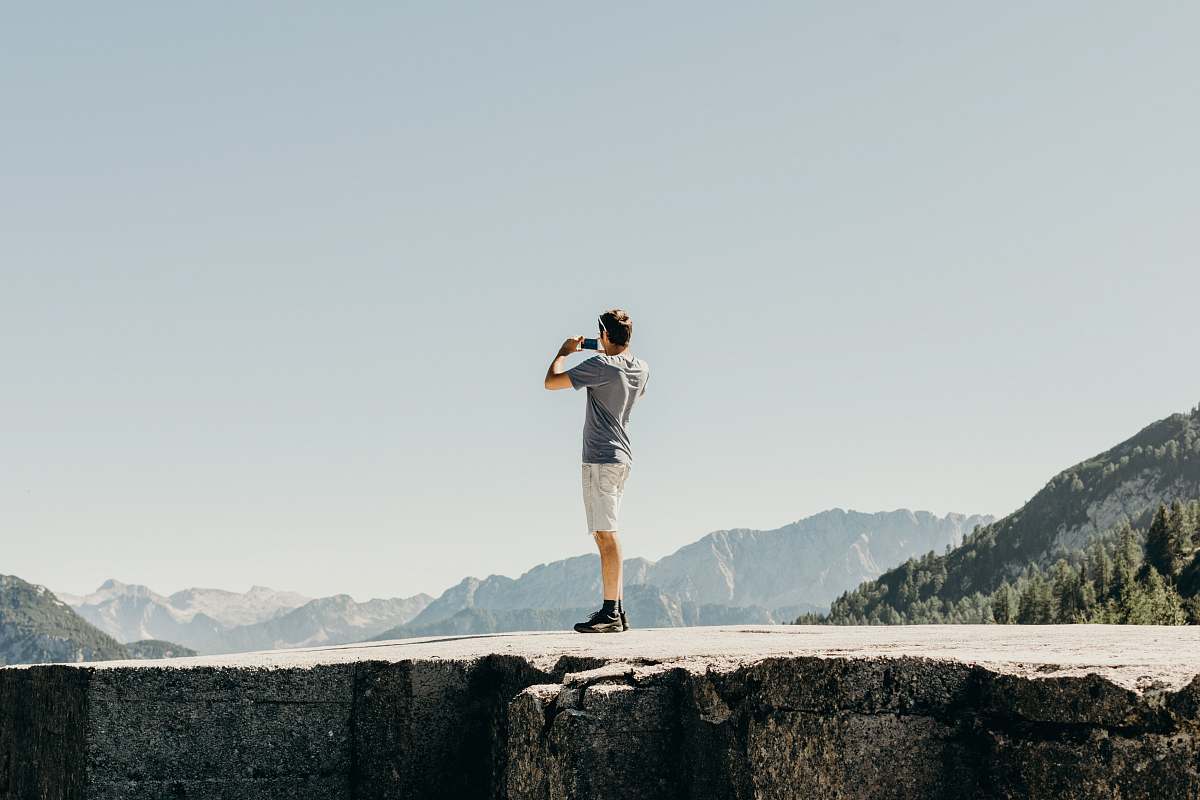 slovenia man standing on gray concrete cliff triglav