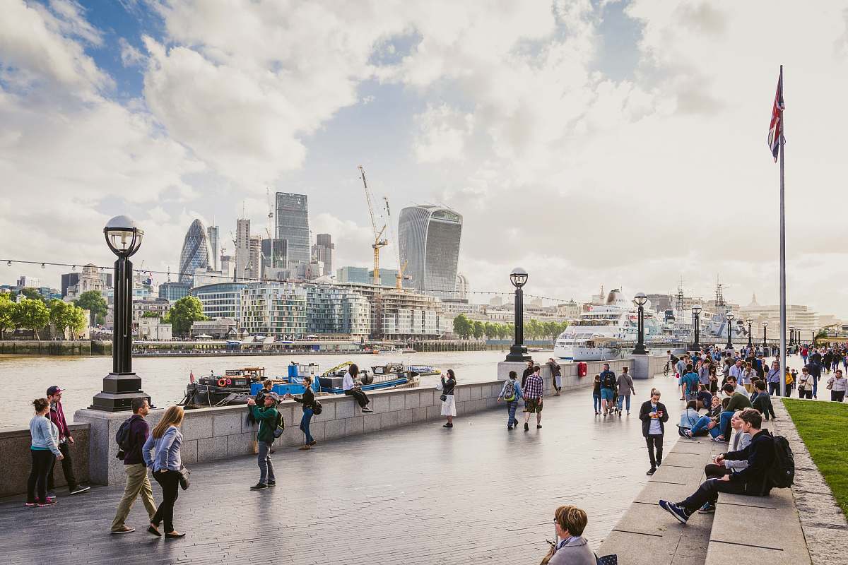 london Tourists strolling on the bank of Thames with the City of London visible on the other shore united kingdom