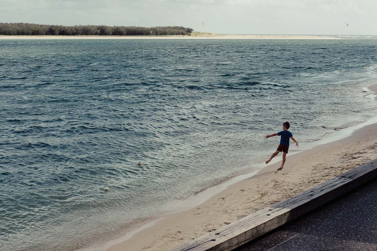person boy playing beside seashore ocean