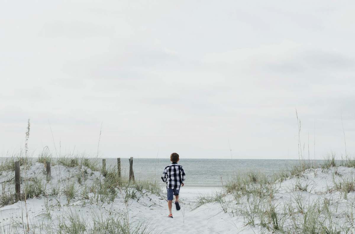 person boy running near body of water people