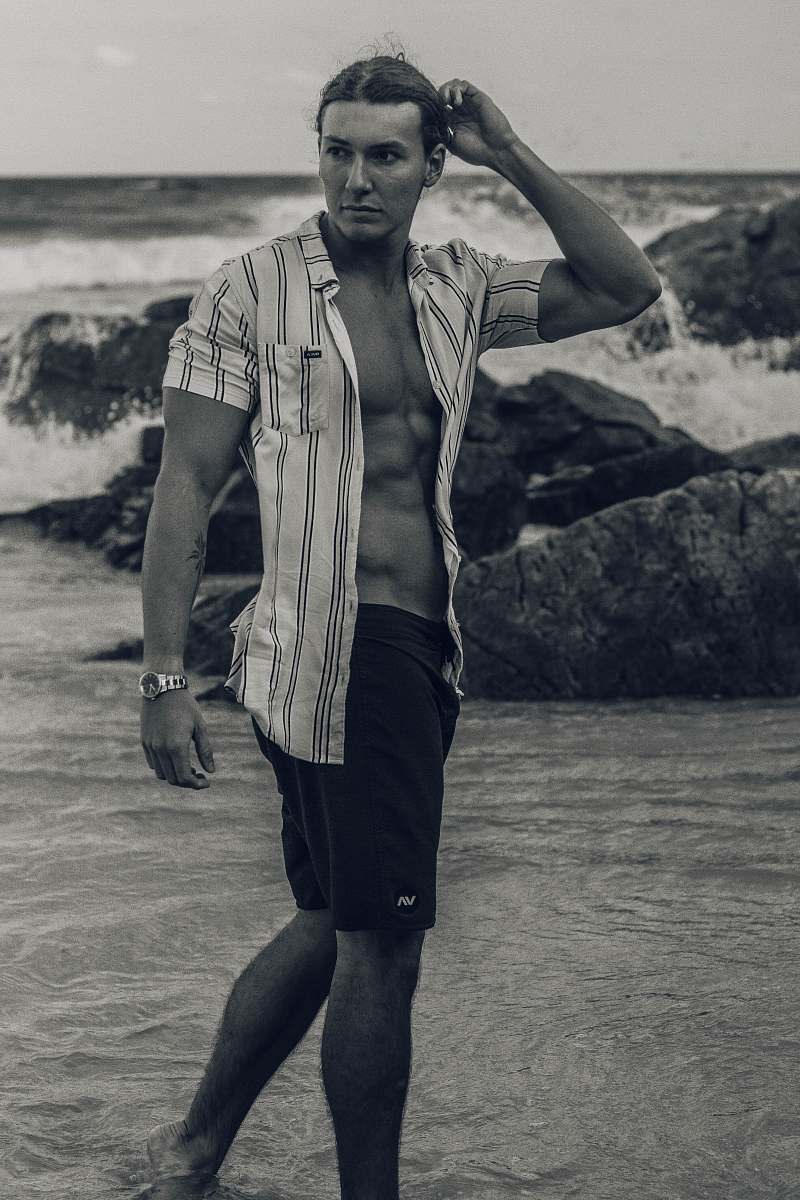 clothing grayscale photo of man standing on seashore apparel