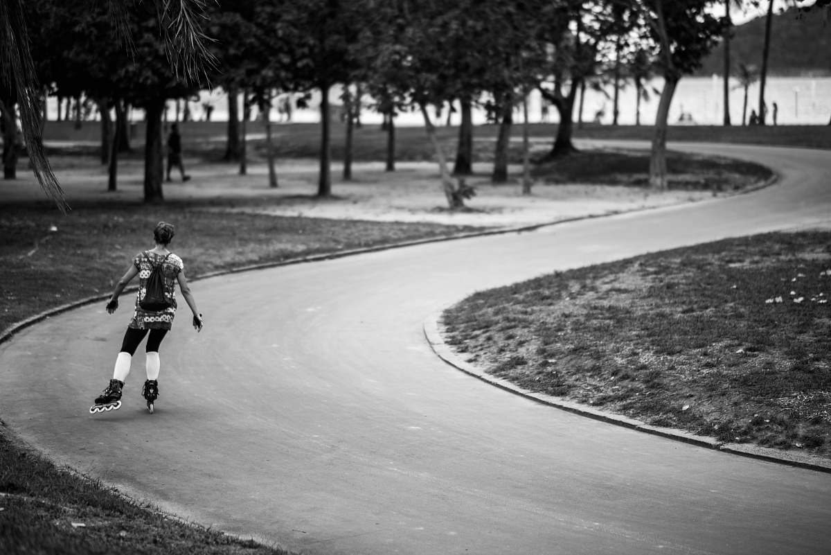 person grayscale photography of girl in inline skates on road black-and-white