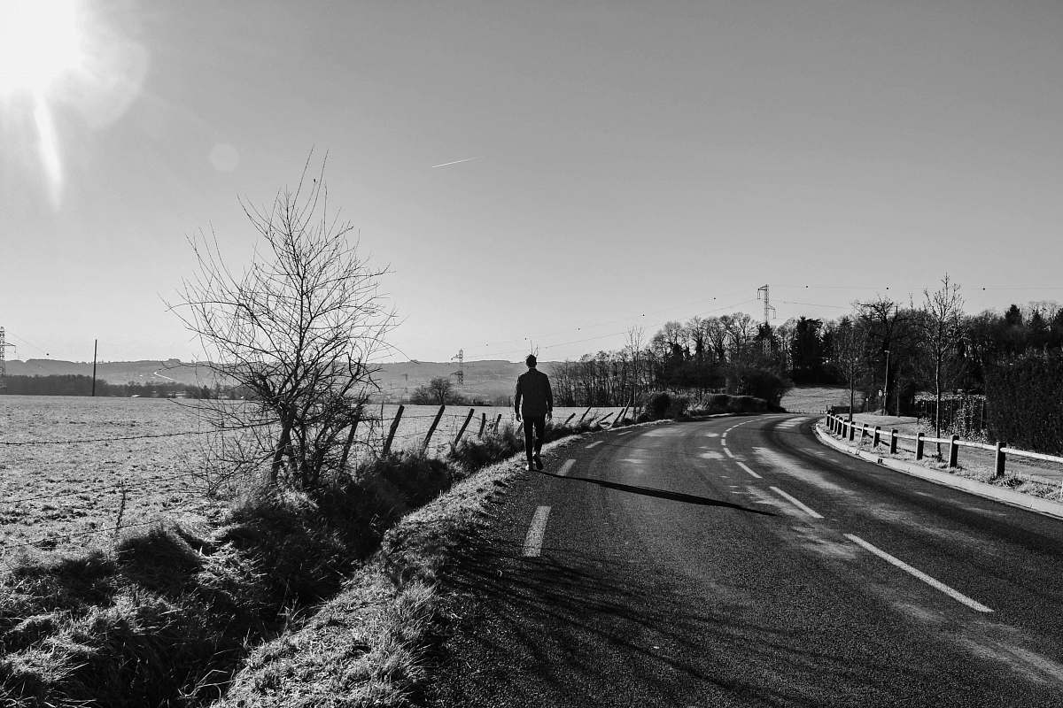 person grayscale photography unknown person walking outdoors black-and-white