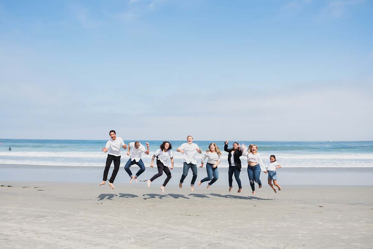 person group of people jumping on seashore people