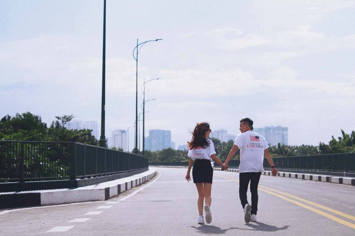 person man and woman holding hands while walking on street apparel