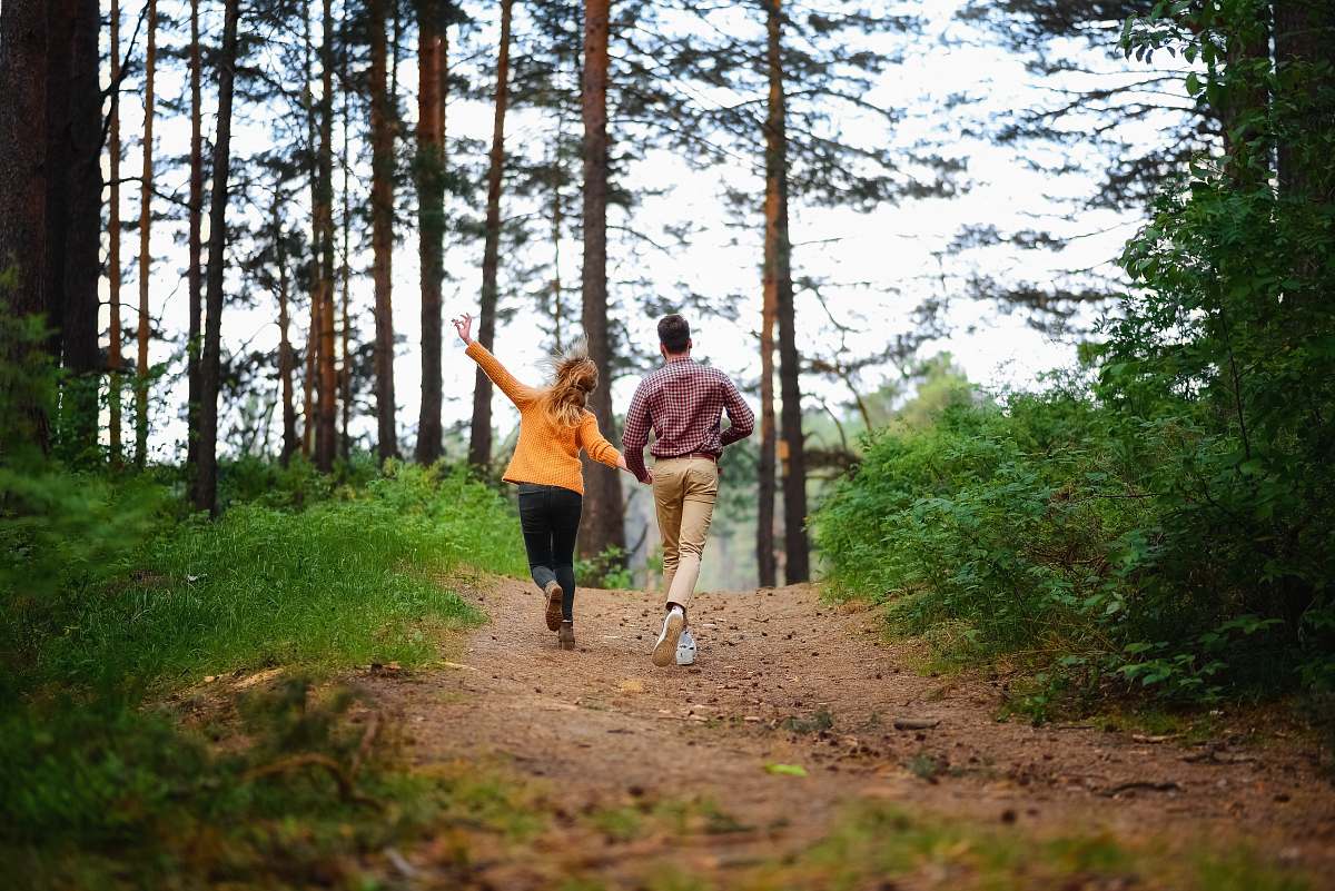 path man and woman walking on forest trail
