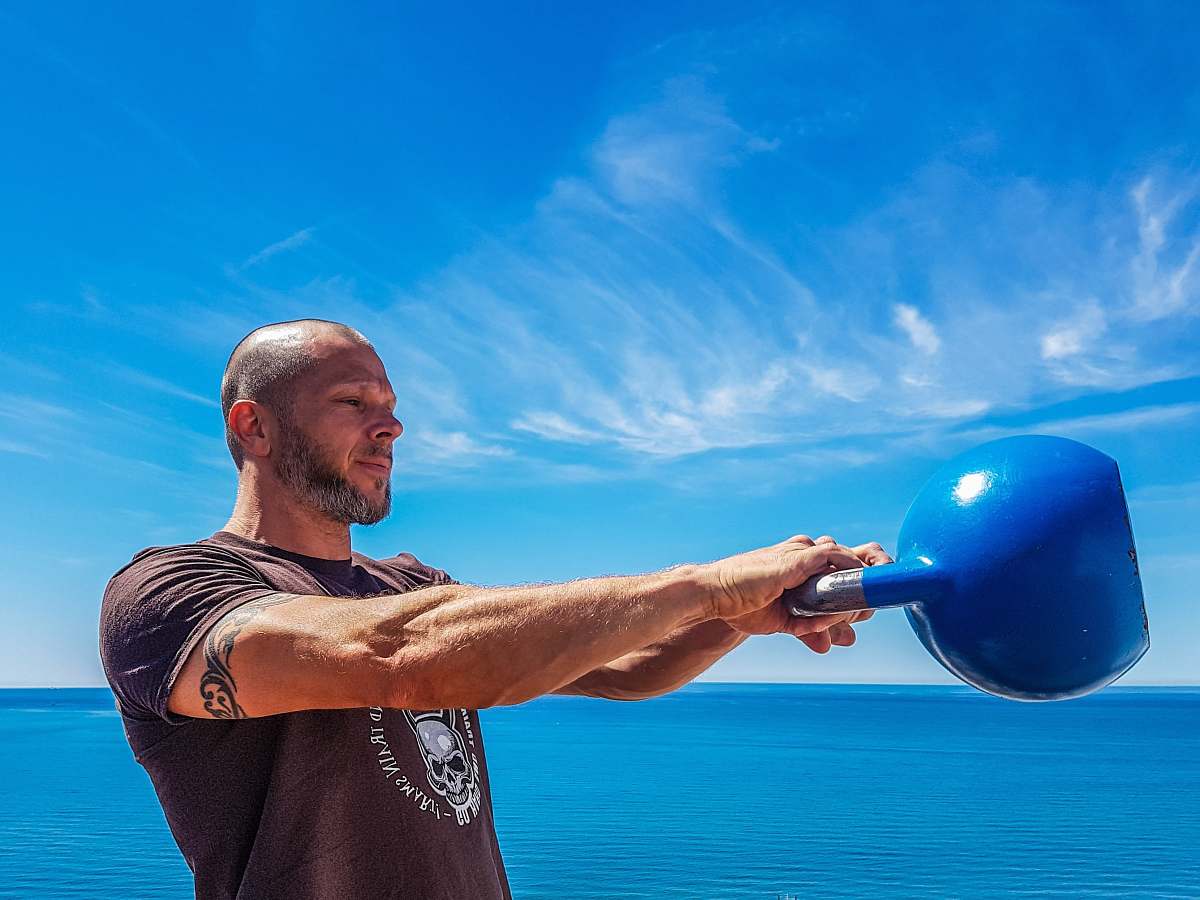 person man carrying blue kettle sphere
