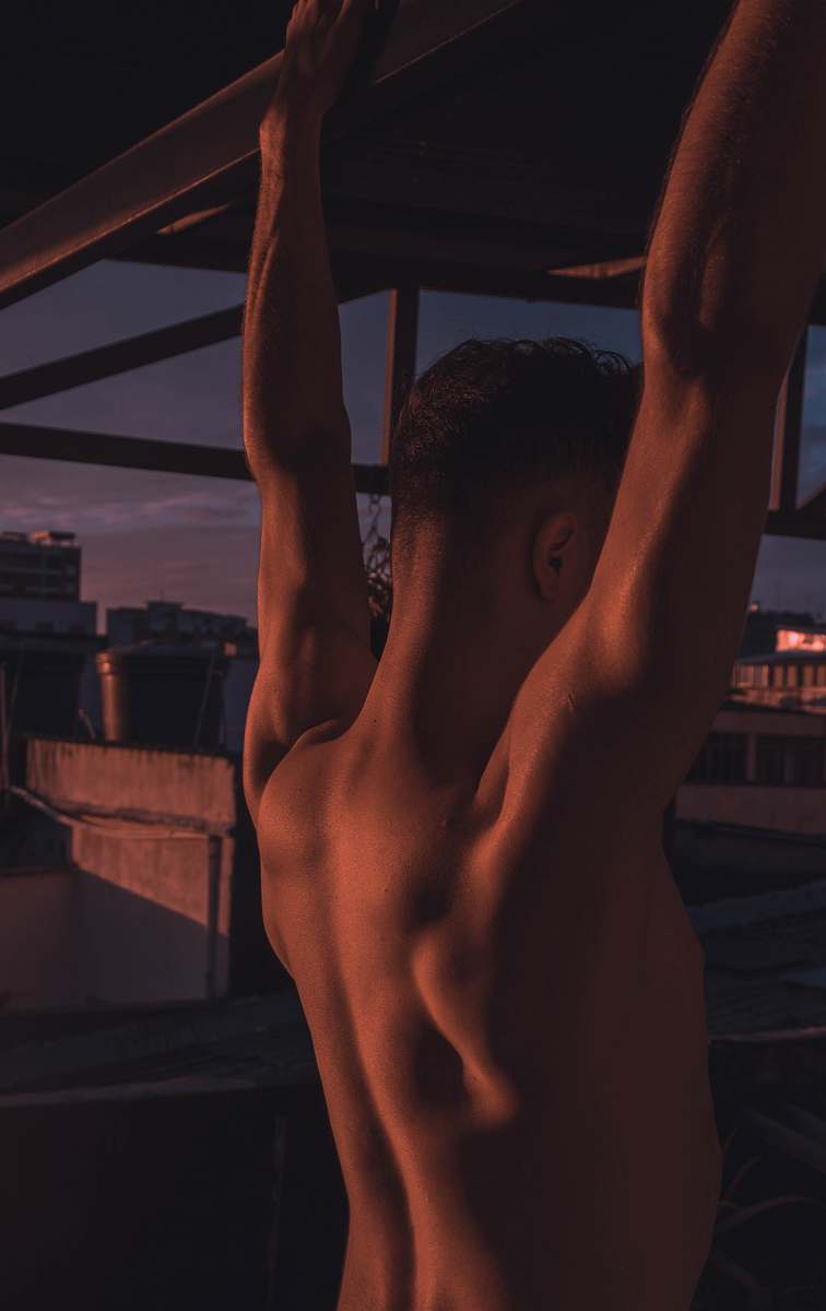 sports man hanging on a concrete bar working out