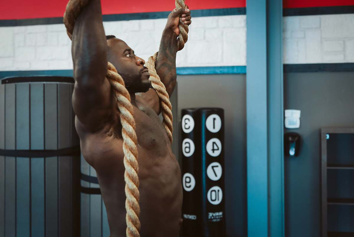 person man holding brown rope exercising exercise