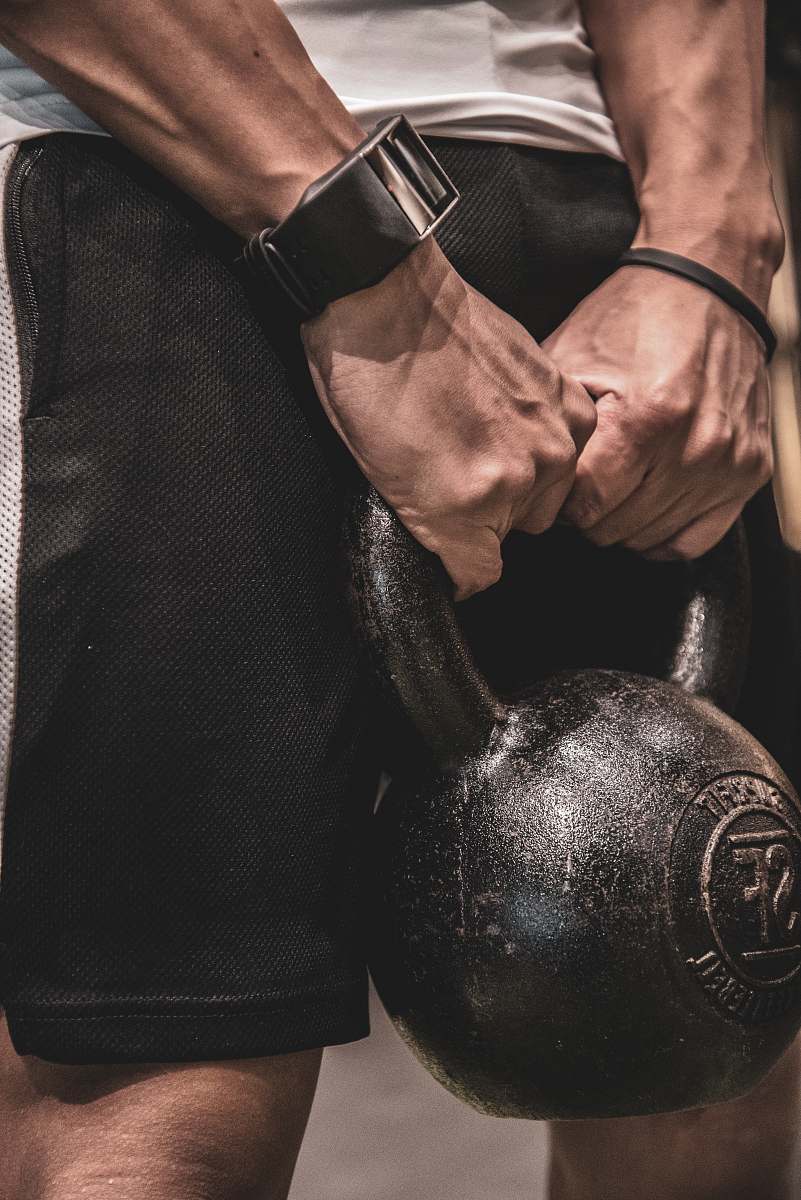 person man holding kettlebell finger