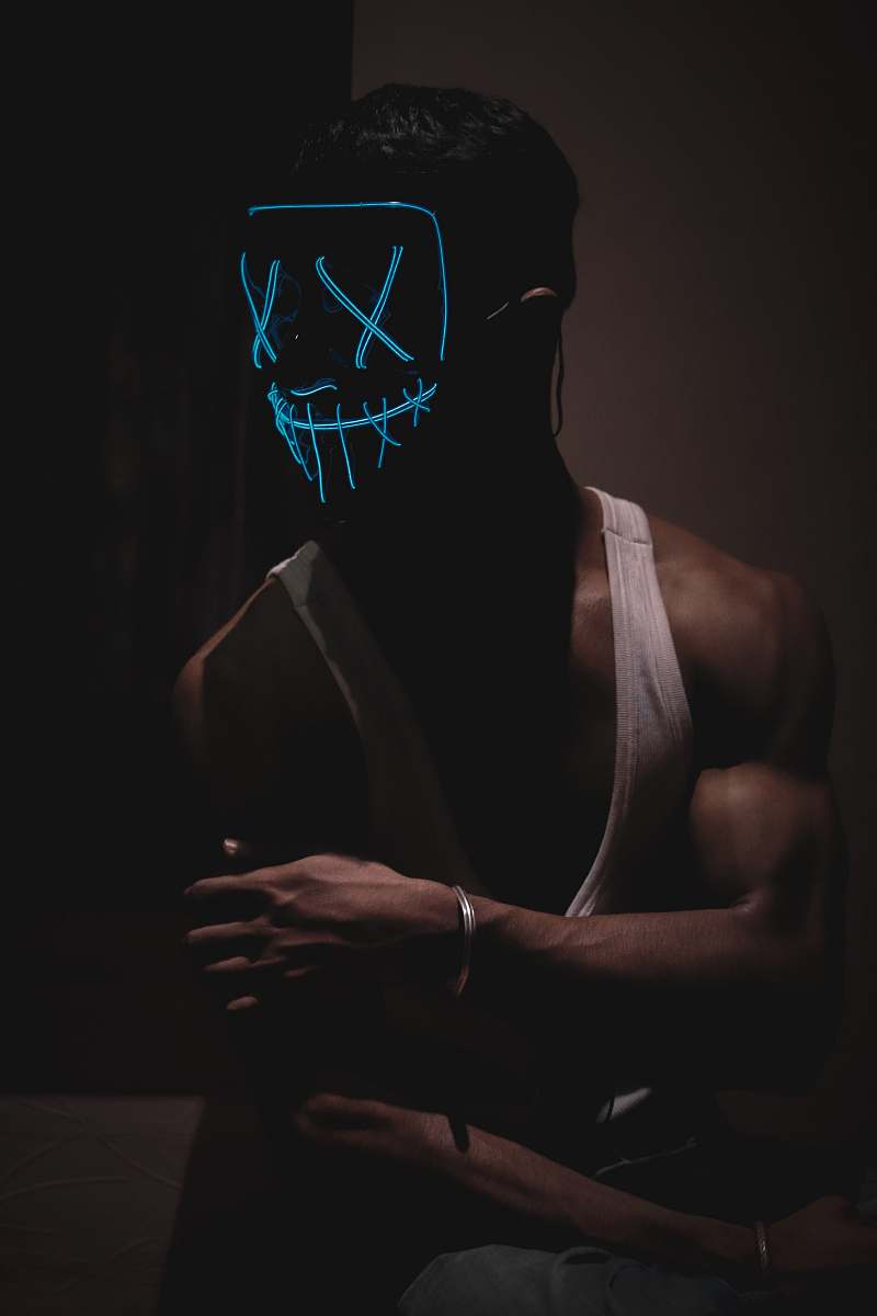 person man in white tank top wearing mask finger
