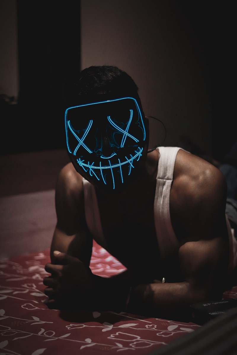 person man leaning forward wearing LED mask fitness