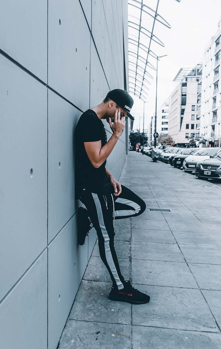 person man leaning on wall people