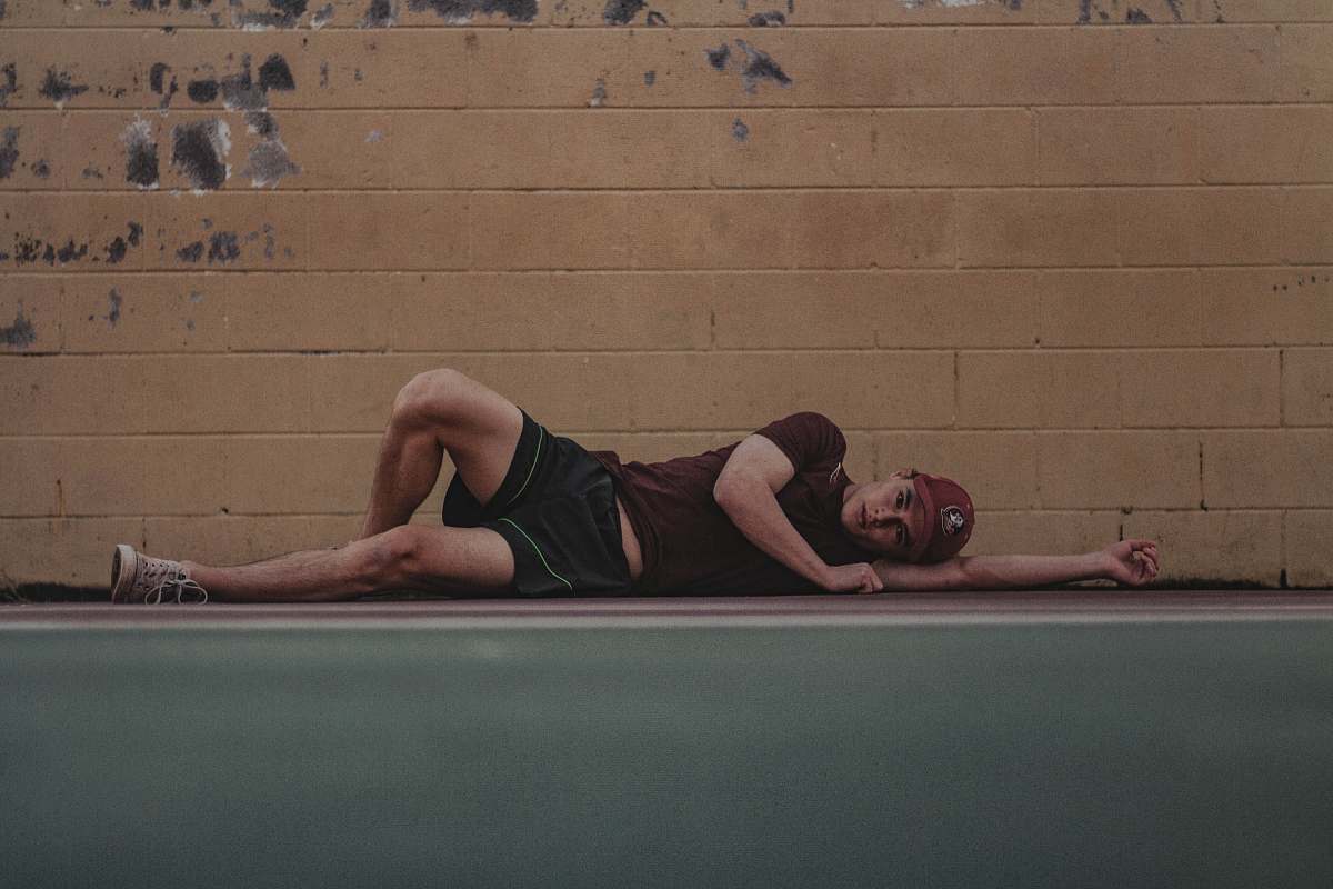 person man lies on sidewalk near wall fitness