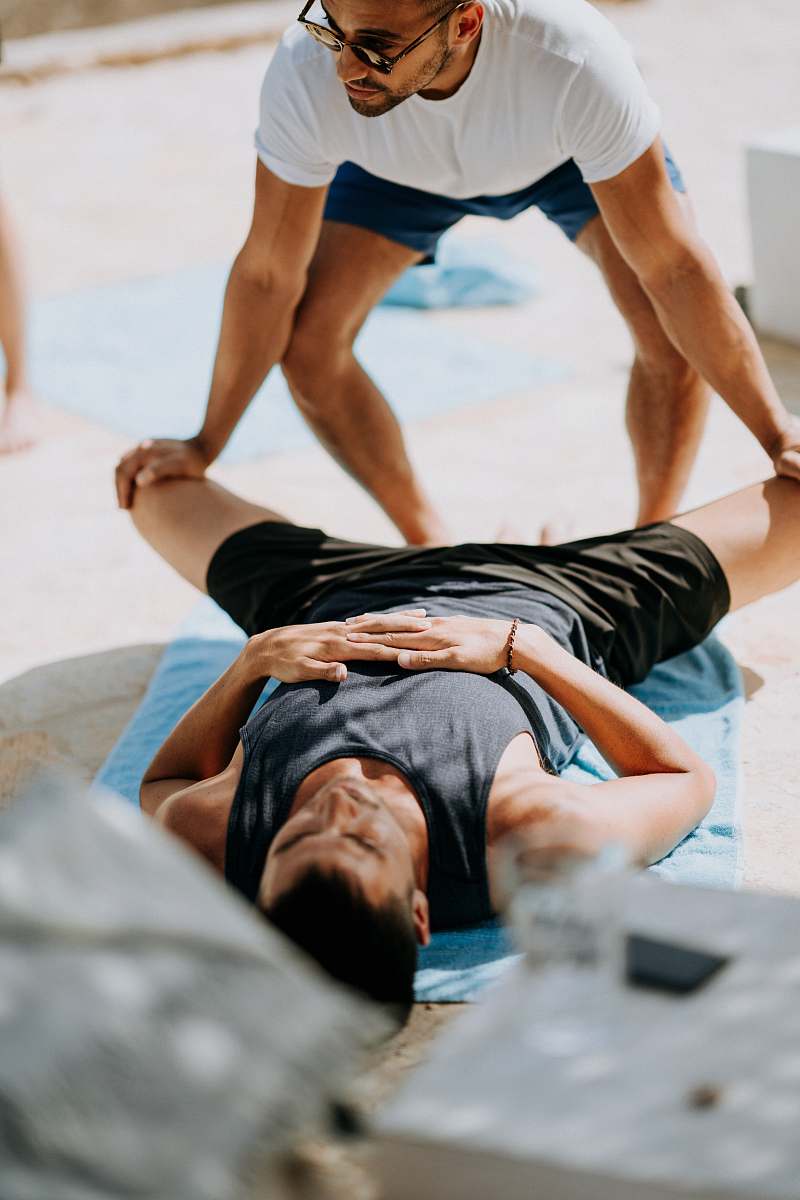person man pressing man's legs during daytime people
