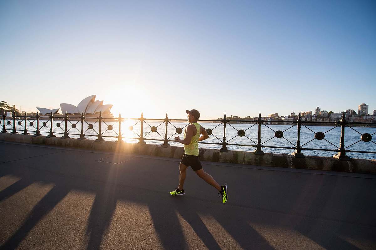 person man running on bay walk during daytime tarmac