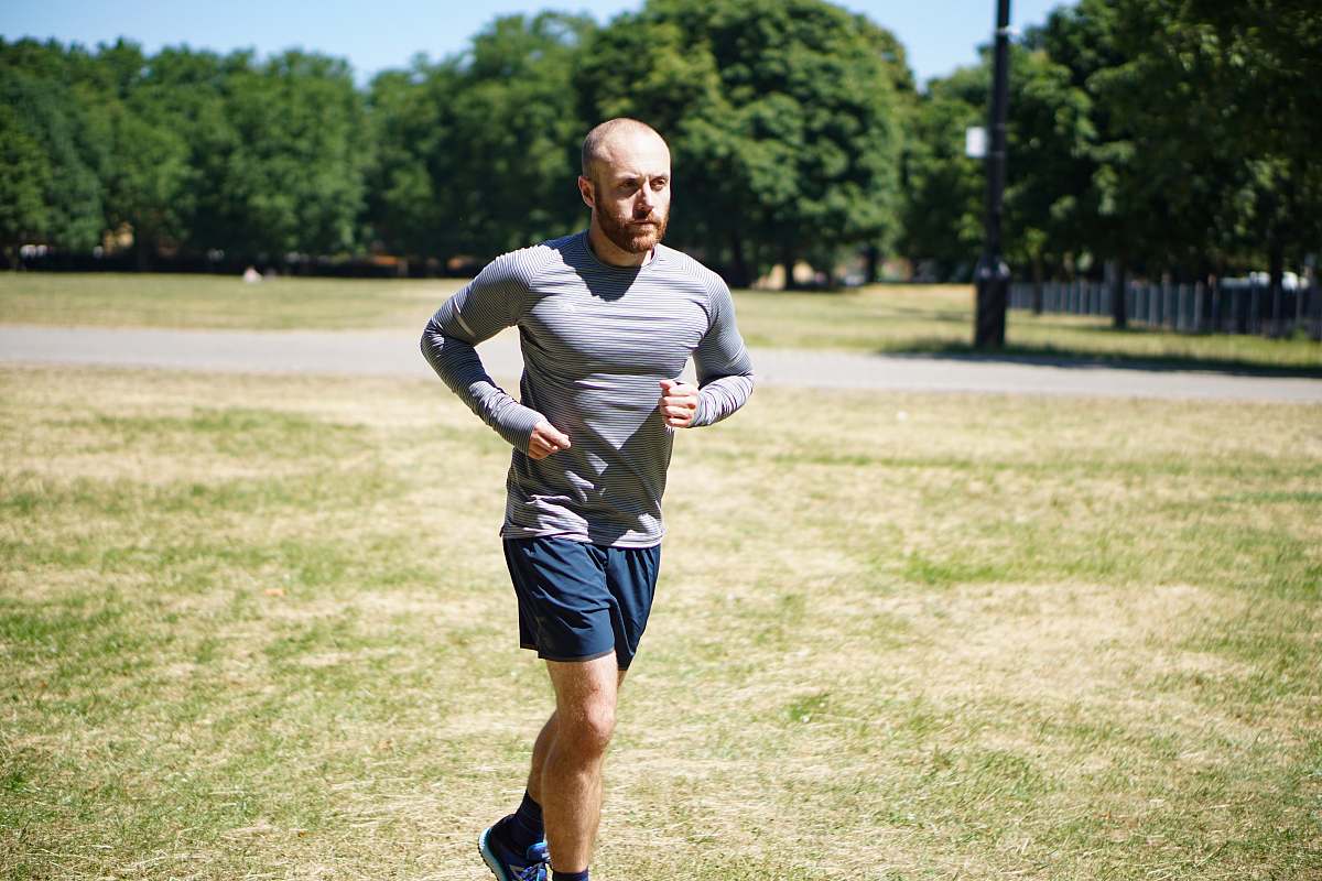 person man running on green field sports