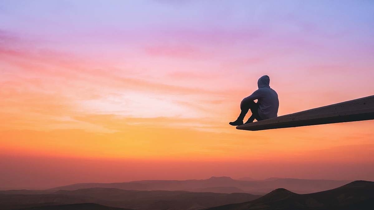 person man sitting on plank outdoors