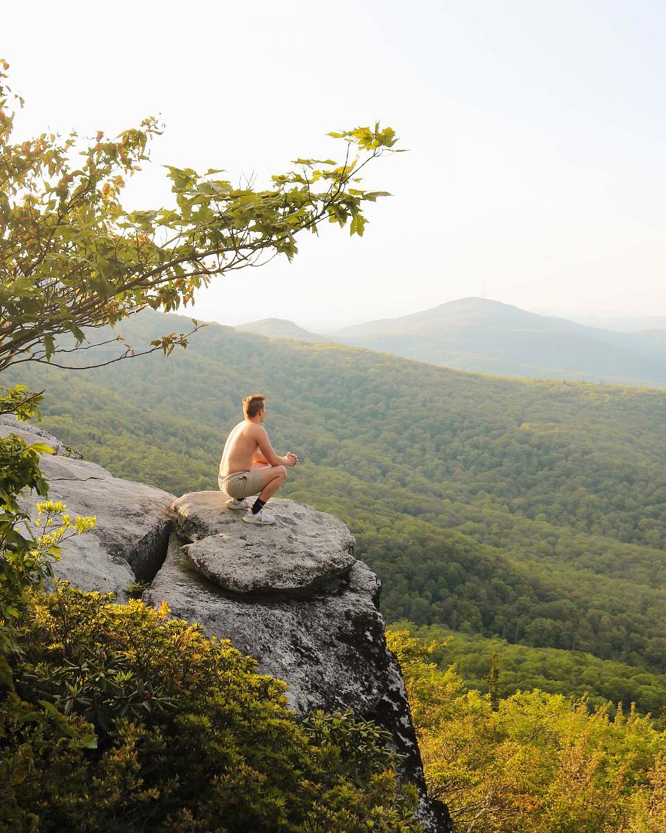person man sitting on rock boulder adventure