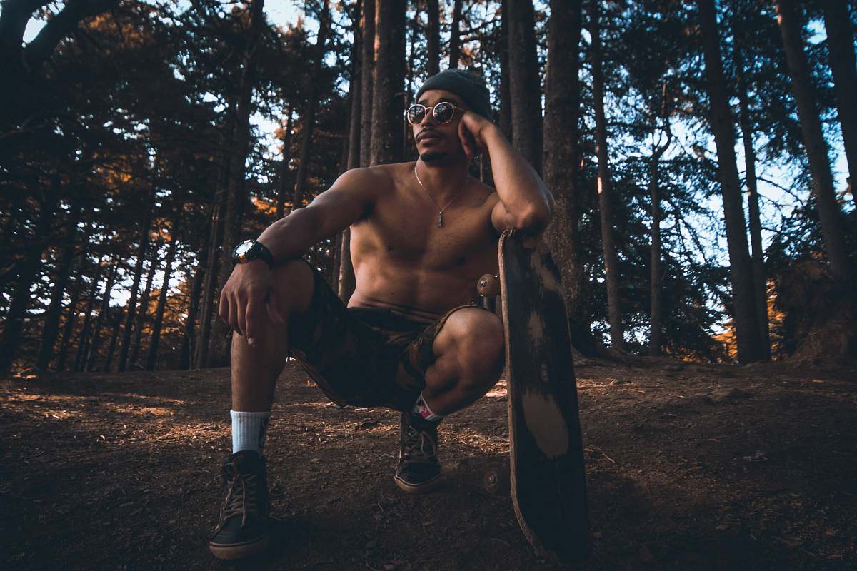 person man sitting on the air leaning on the surfboard on forest clothing