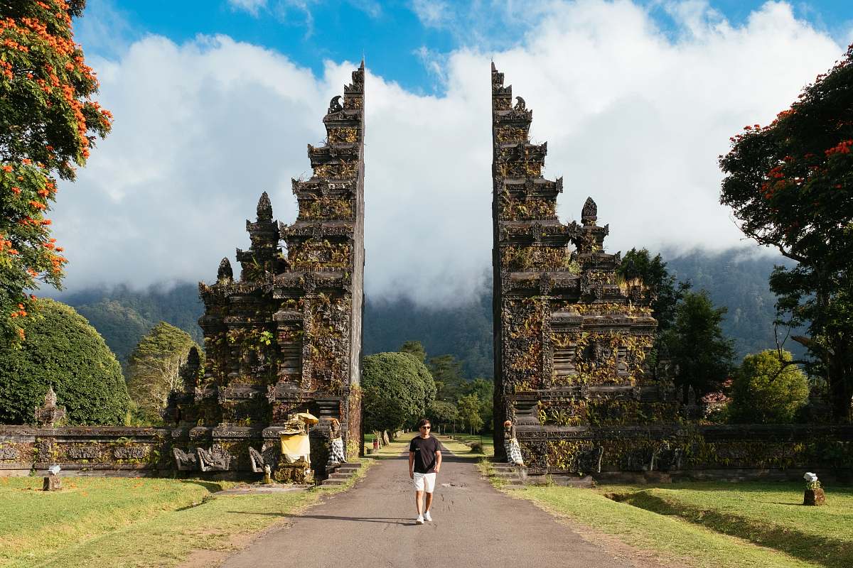 person man walking between building under white clouds temple