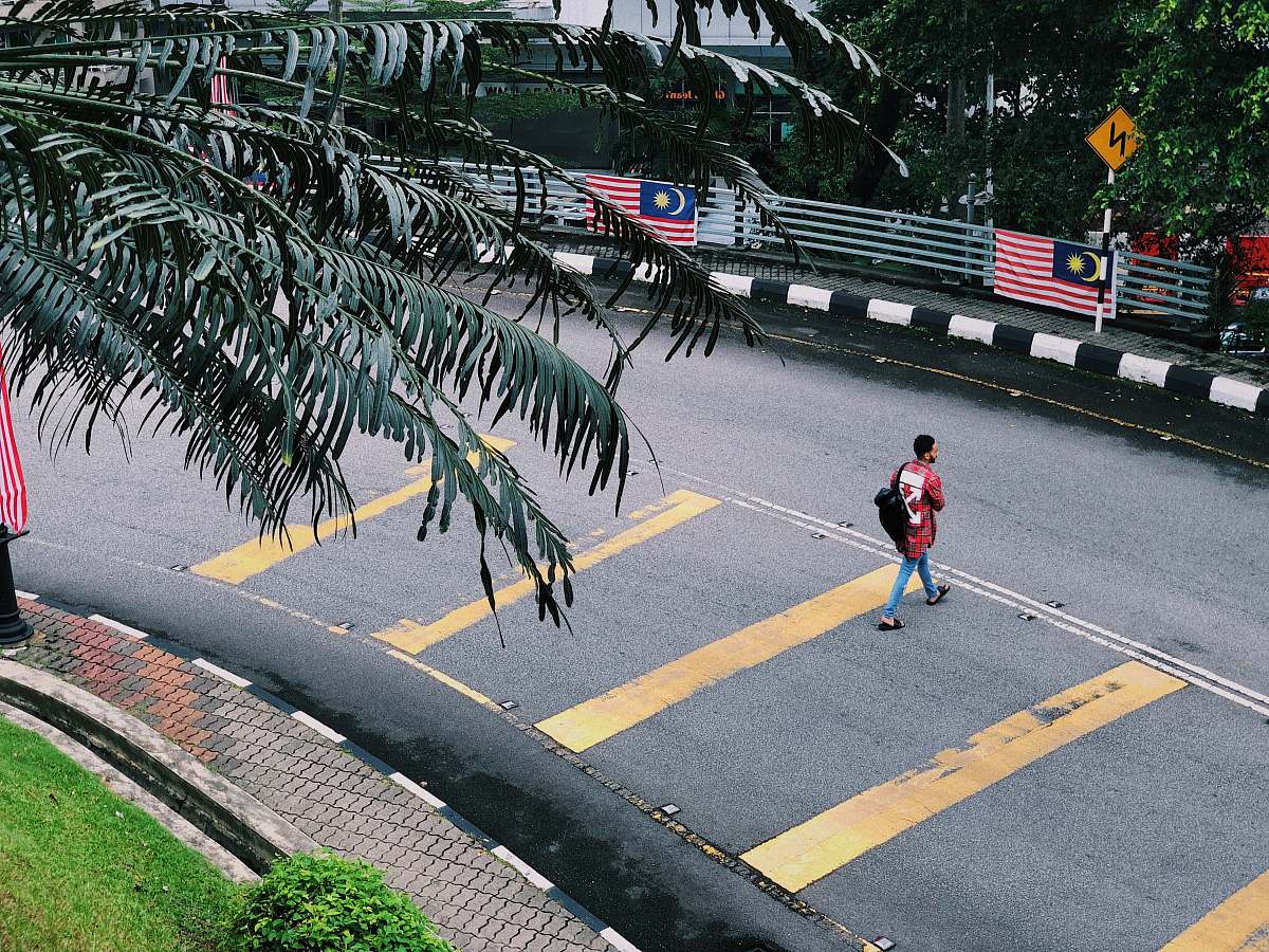 asphalt man walking on concrete road during daytime tarmac
