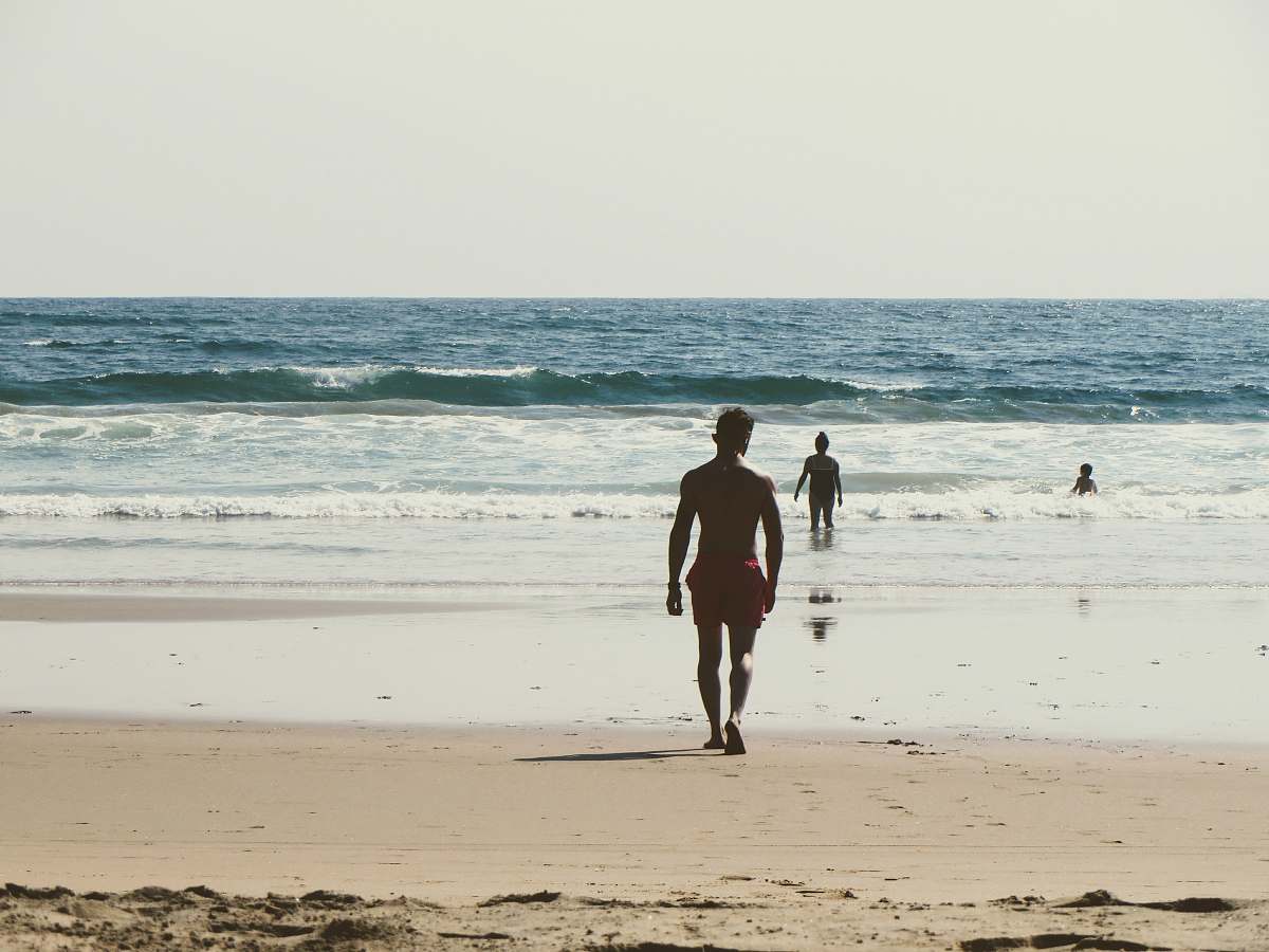 person man walking towards shore during daytime people