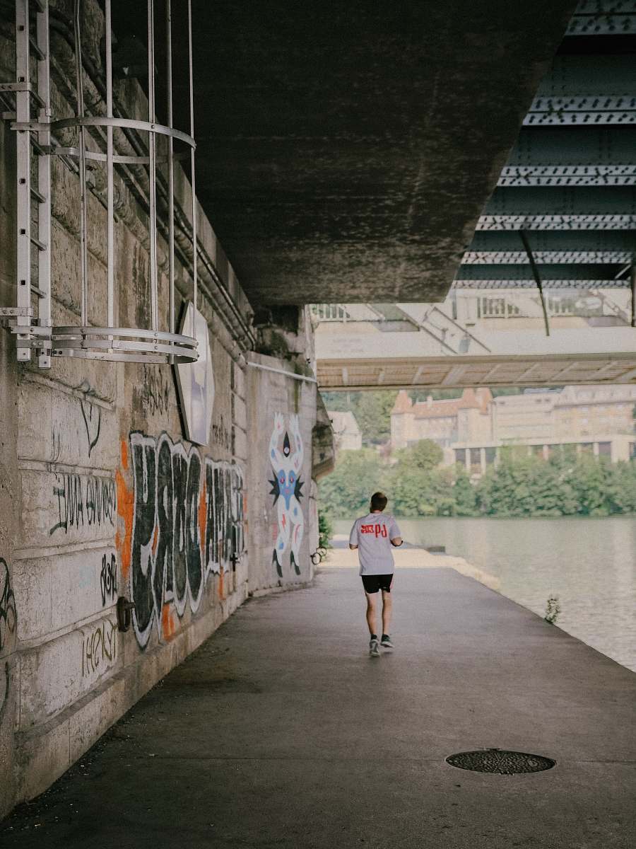 person man wearing white T-shirt walking on sidewalk sport