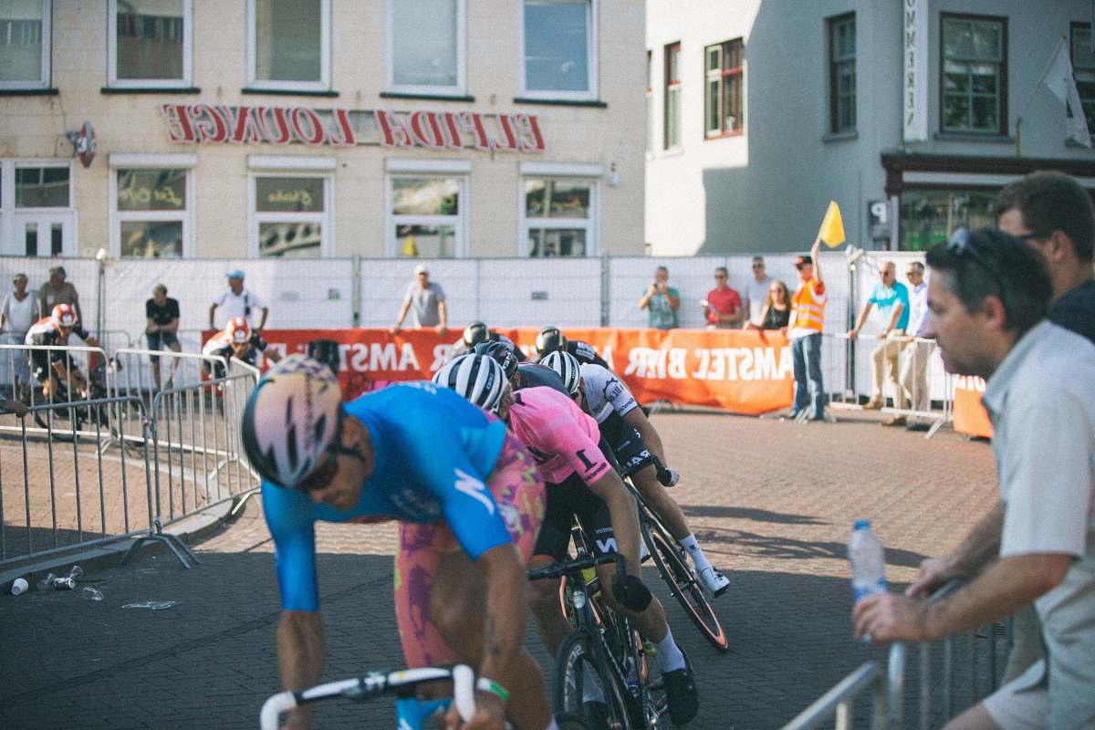 person men riding road bikes near handrails and people bicycle