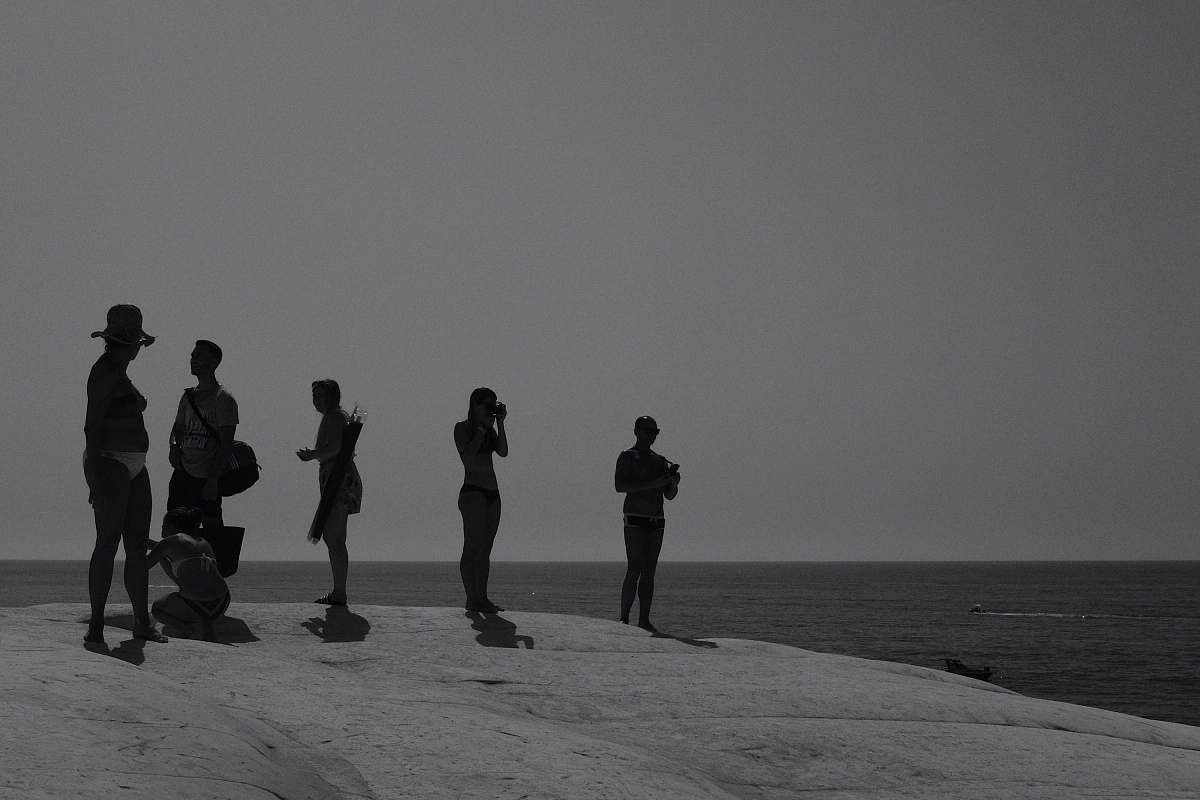 person people standing on beach black-and-white