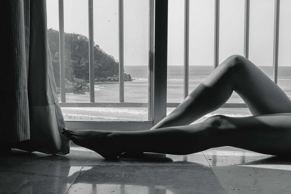 black-and-white person lying beside rails grey