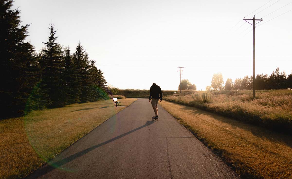 person person standing in the middle of the road near trees path