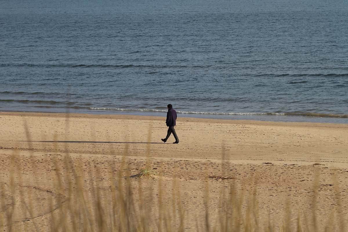 person person walking near beach line sand