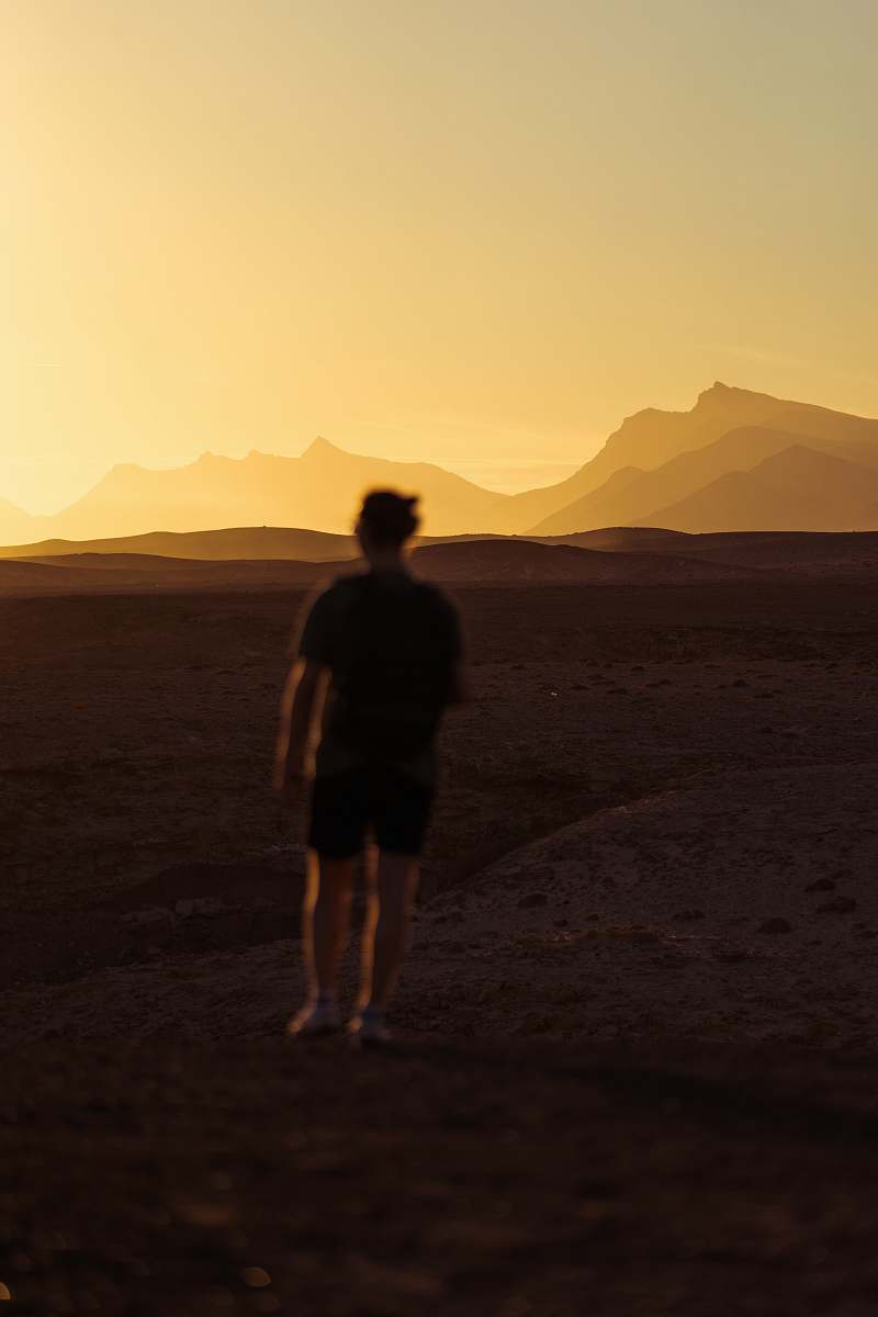 person person walking on desert during golden hour people