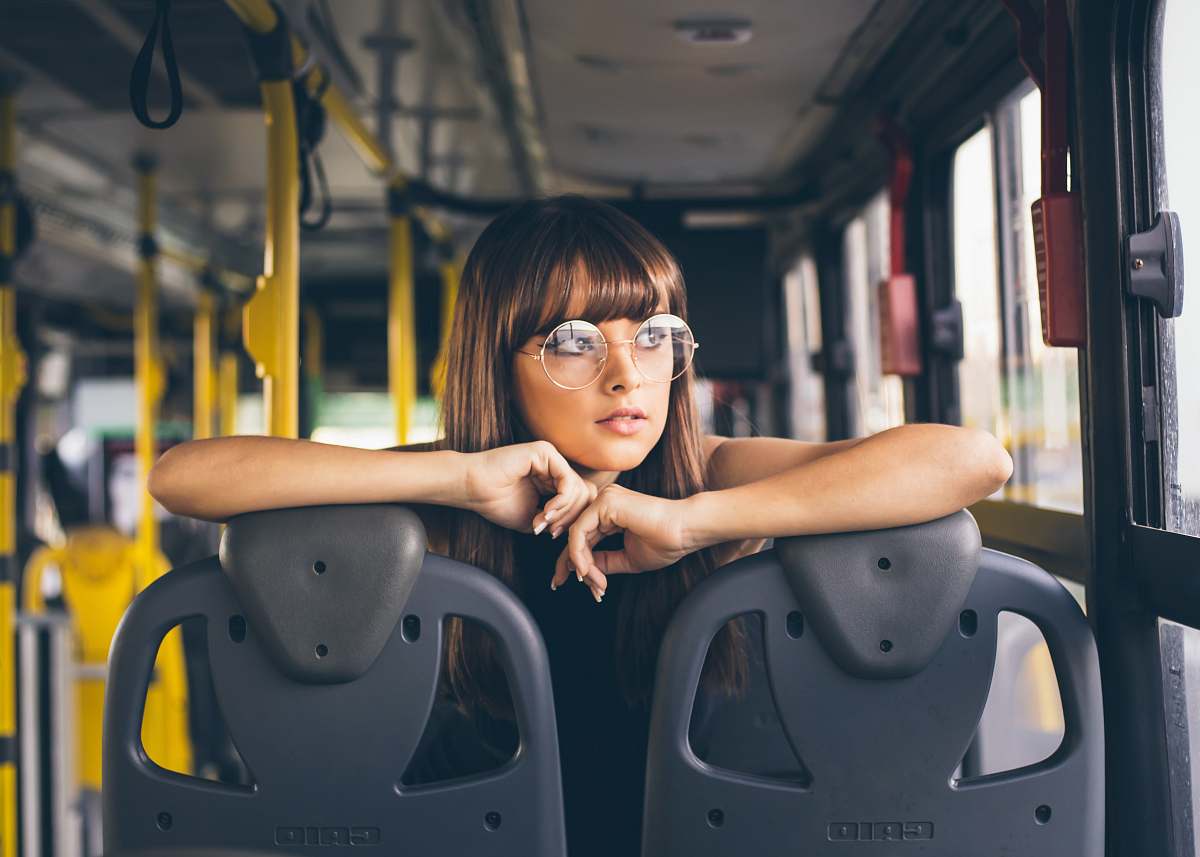 person selective focus photography of woman wearing eyeglases riding bus face