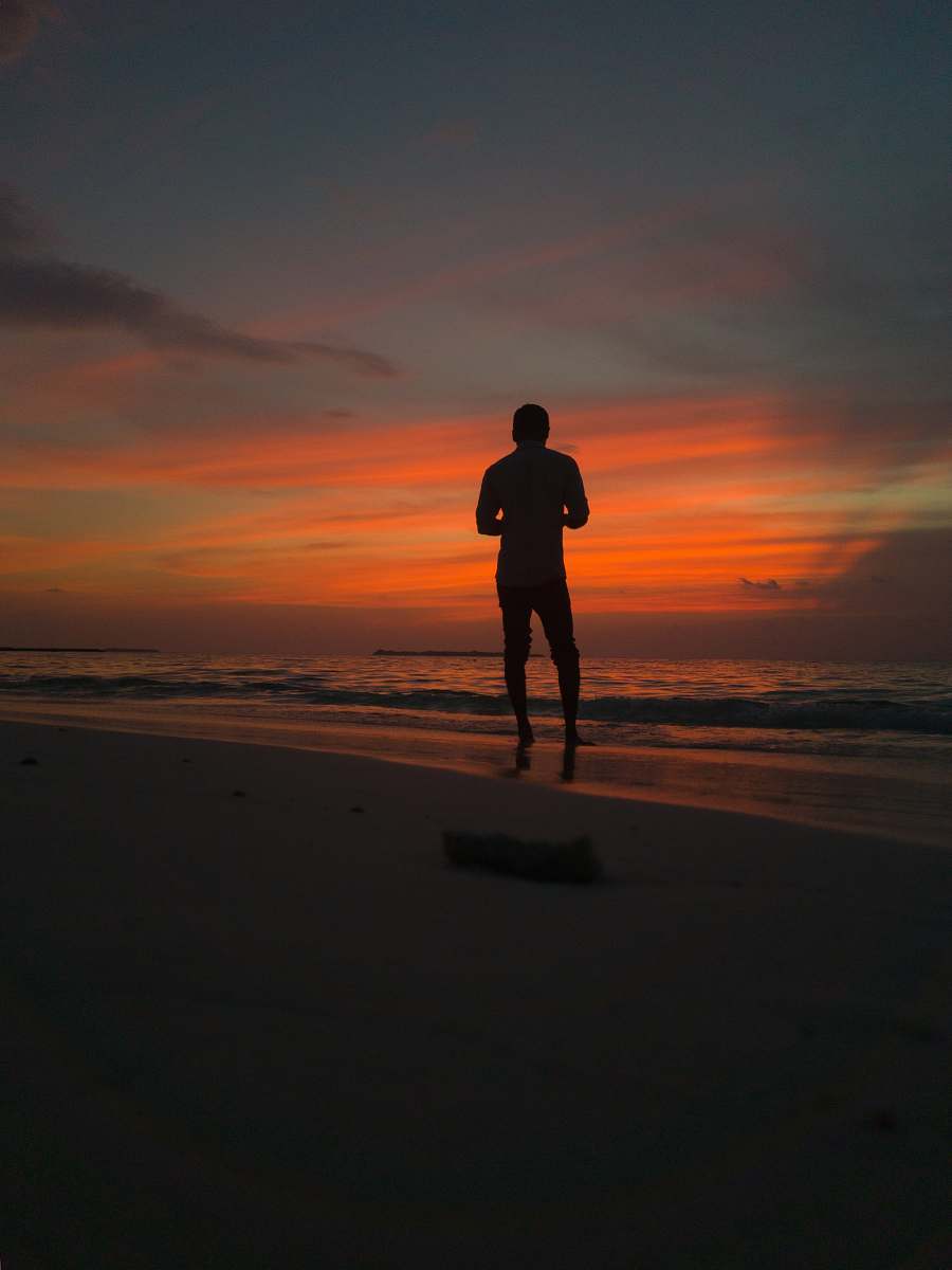 person silhouette of man standing on shore working out