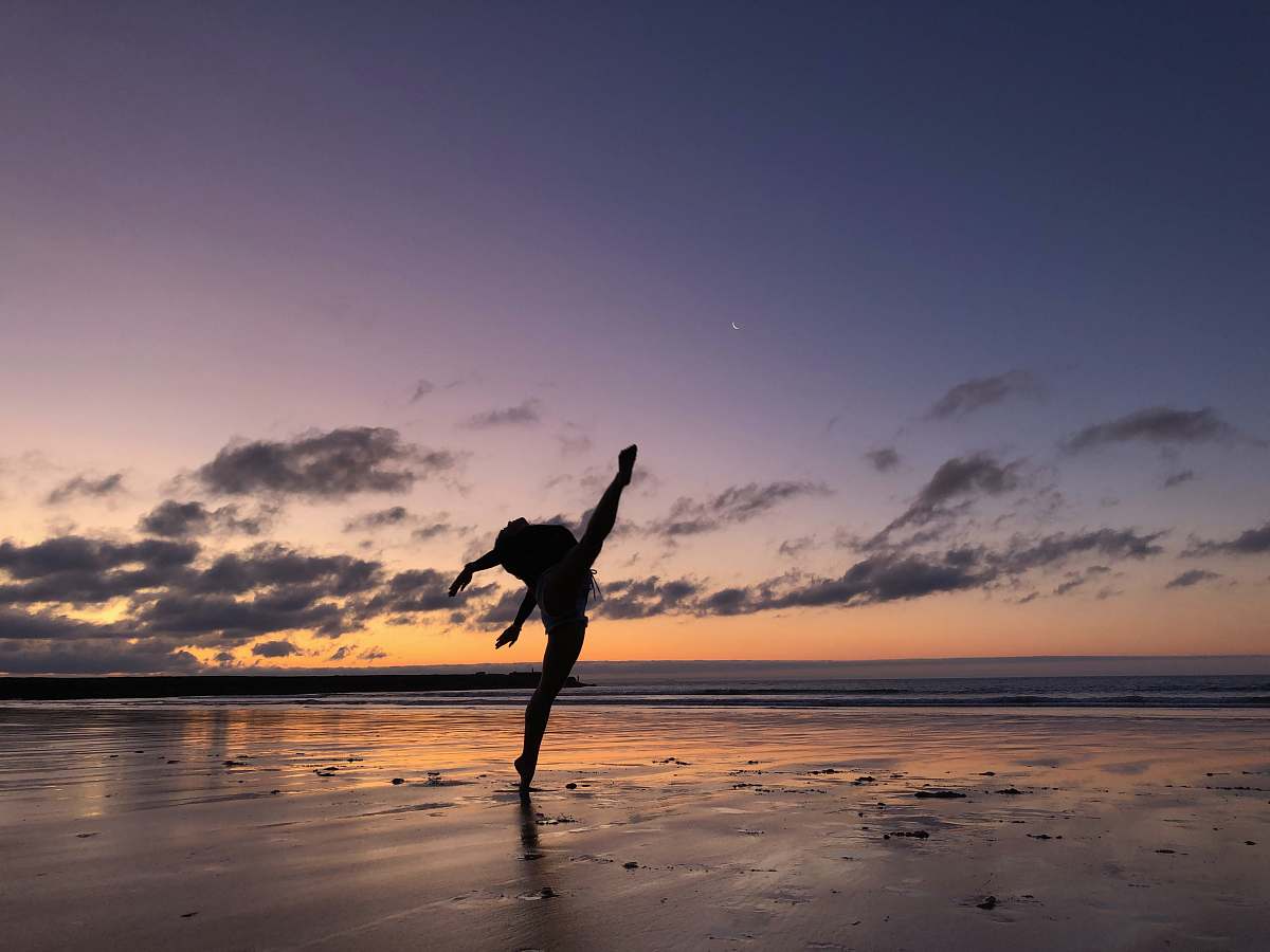 person silhouette of woman dancing on the seashore leisure activities