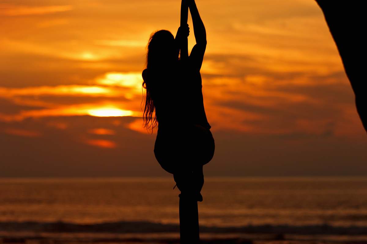 person silhouette photo of a man holding rope on seashore during sunset people